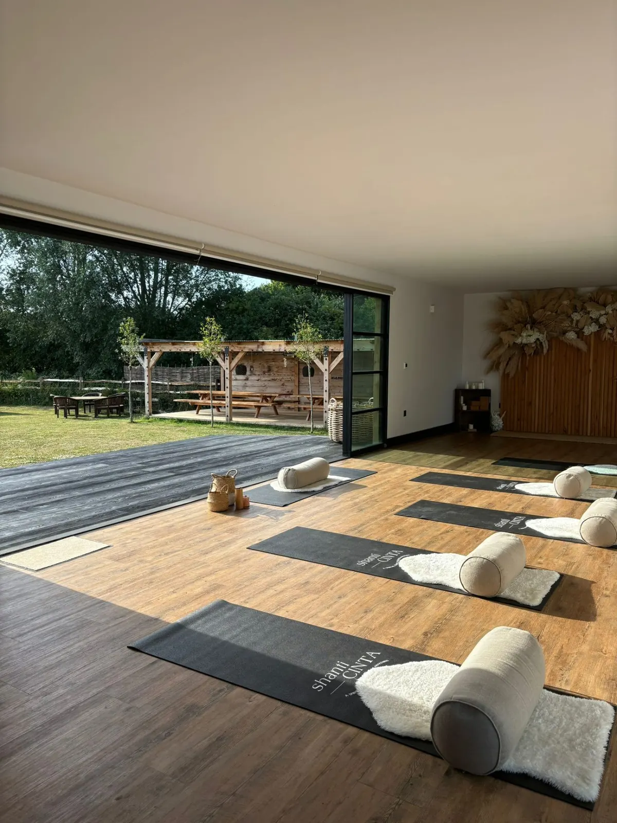 Yoga studio with mats laid out and open doors onto the field